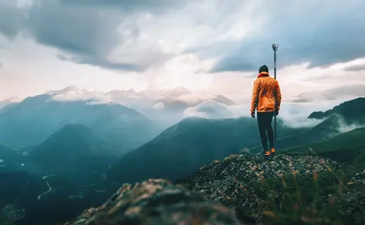 Topógrafo con GNSS R12i en cima de montaña