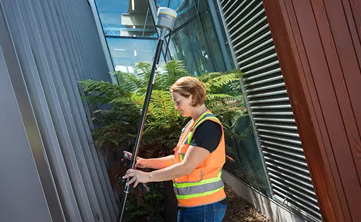 Topógrafo operando receptor GNSS Trimble R980 en levantamiento de entorno urbano