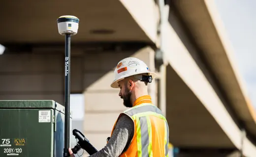Topógrafo operando receptor GNSS Trimble R580 en levantamiento de entorno urbano