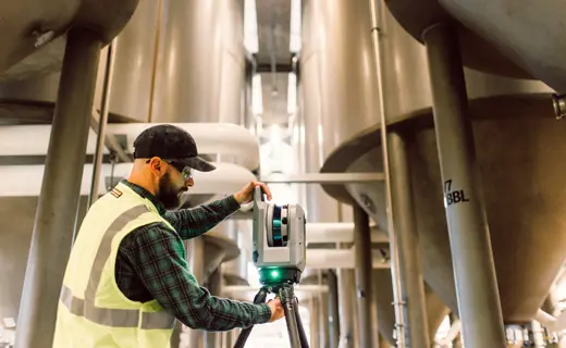 Escáner láser Trimble X9 realizando captura 3D en interior de entorno industrial