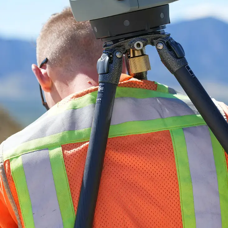 Técnico caminando con escáner láser Trimble al hombro