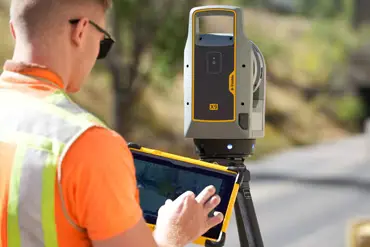 Operario configurando escáner láser Trimble X9 para escaneo en obra civil